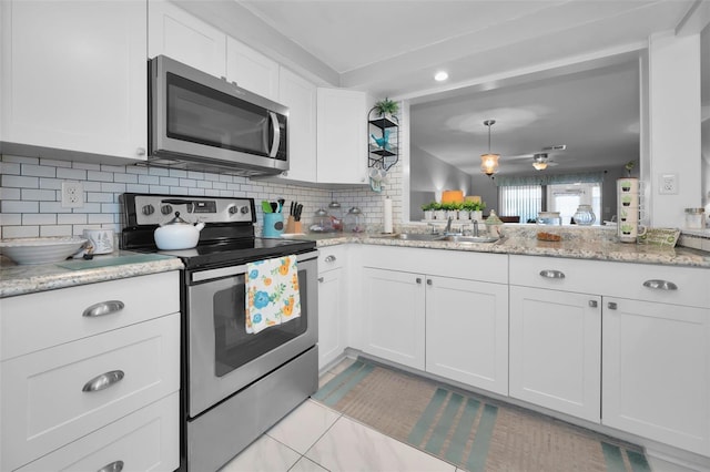 kitchen featuring backsplash, sink, light tile patterned floors, white cabinetry, and stainless steel appliances