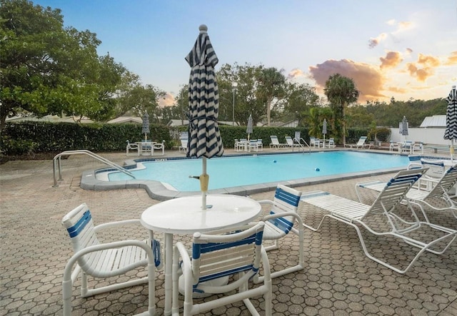 pool at dusk with a patio