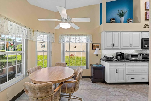 interior space with light tile patterned floors, high vaulted ceiling, and ceiling fan