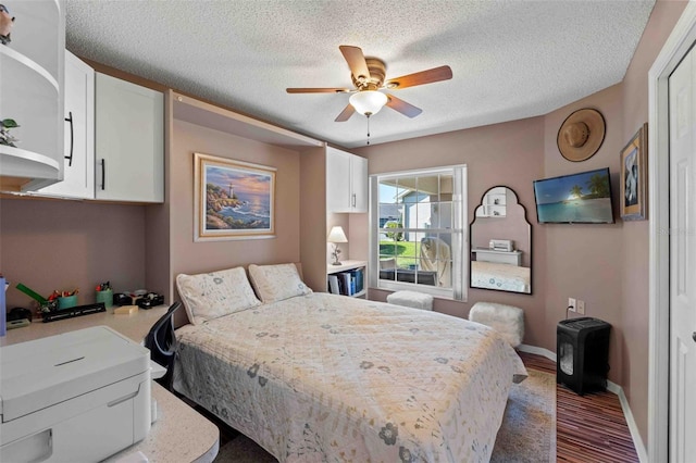 bedroom featuring ceiling fan, wood-type flooring, and a textured ceiling