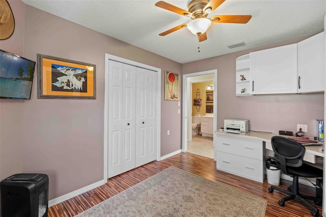 home office featuring ceiling fan, light hardwood / wood-style floors, and a textured ceiling