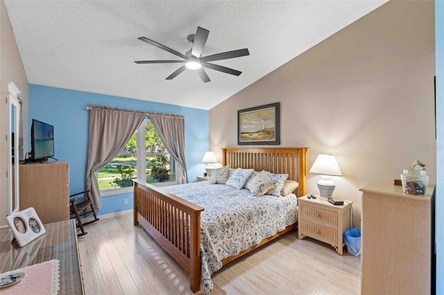 bedroom featuring a textured ceiling, ceiling fan, hardwood / wood-style floors, and lofted ceiling