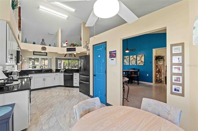 kitchen featuring appliances with stainless steel finishes, white cabinetry, ceiling fan, and sink