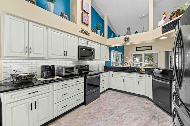 kitchen with white cabinets, high vaulted ceiling, and appliances with stainless steel finishes