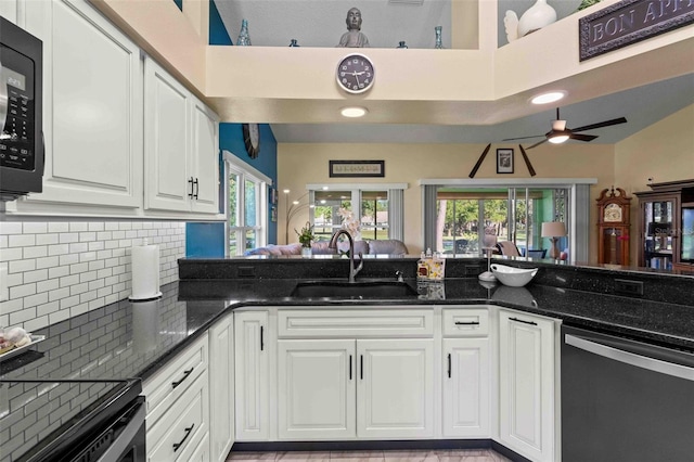 kitchen featuring dark stone counters, white cabinetry, sink, and stainless steel dishwasher