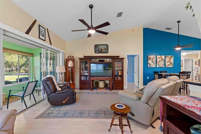 living room featuring ceiling fan, light wood-type flooring, and high vaulted ceiling