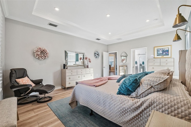 bedroom with a tray ceiling, light hardwood / wood-style flooring, and ornamental molding