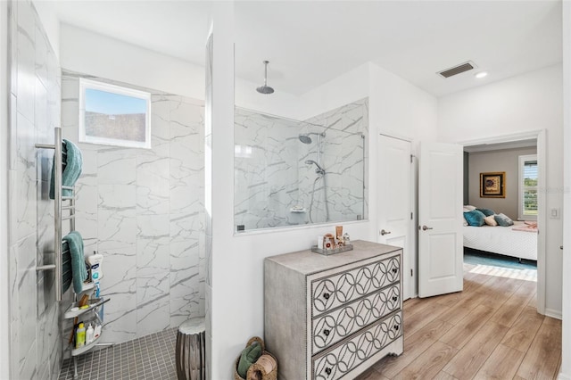 bathroom featuring hardwood / wood-style floors and tiled shower