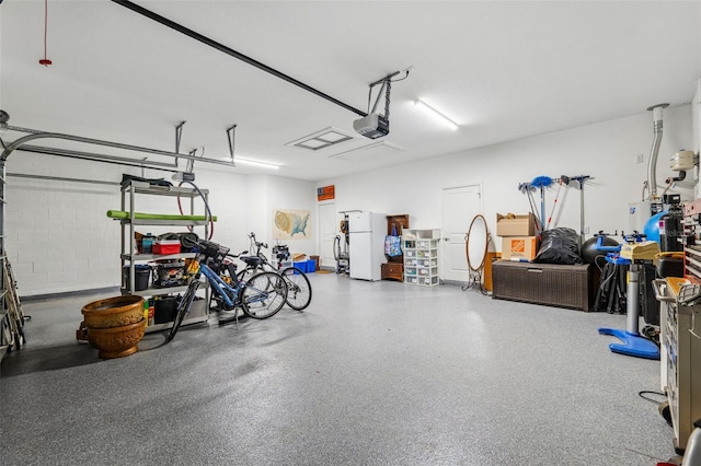 garage featuring a garage door opener and white refrigerator