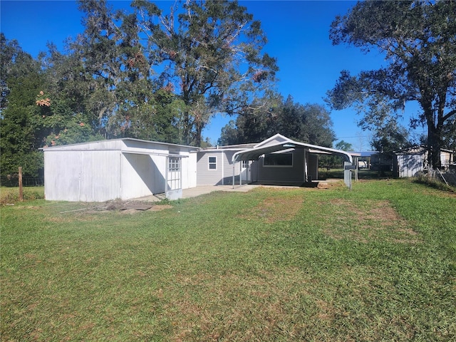 back of property featuring a lawn and a carport