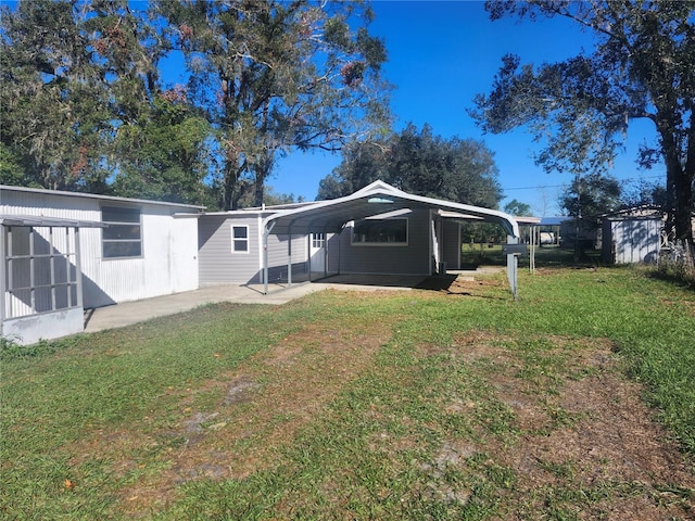 back of house featuring a carport and a lawn