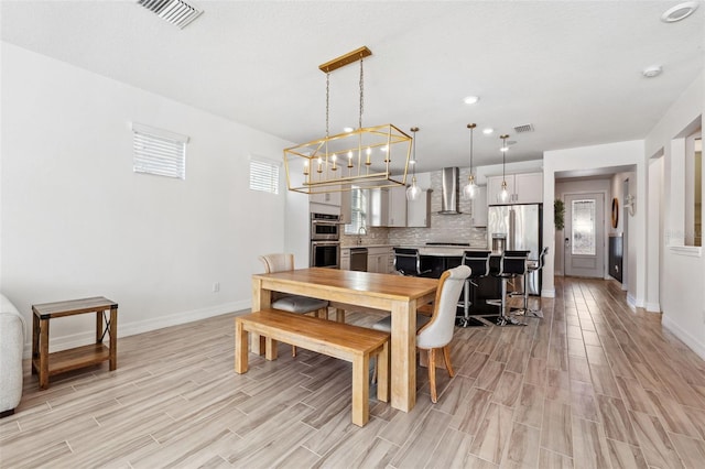 dining room featuring light hardwood / wood-style floors and a chandelier