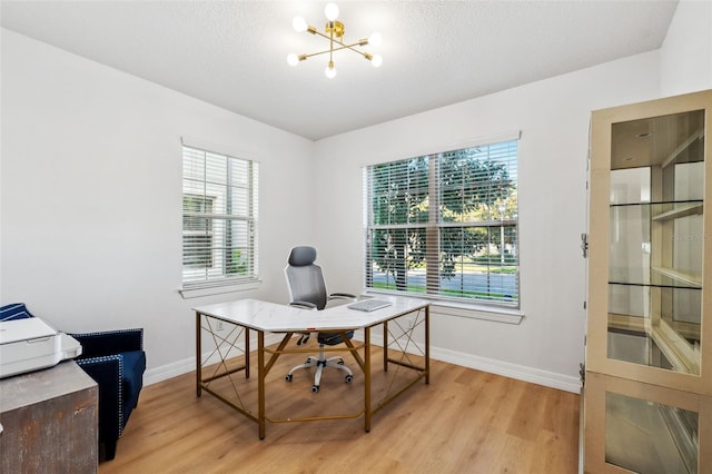 office featuring a chandelier, a textured ceiling, light hardwood / wood-style floors, and a healthy amount of sunlight