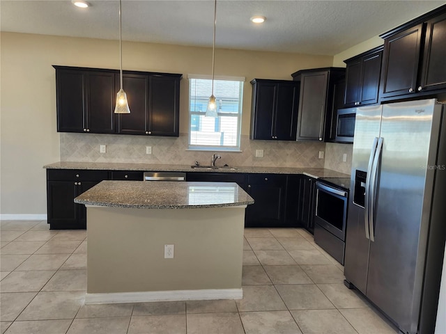 kitchen featuring sink, a kitchen island, hanging light fixtures, and appliances with stainless steel finishes