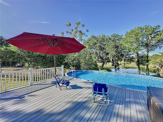 view of swimming pool with a deck with water view