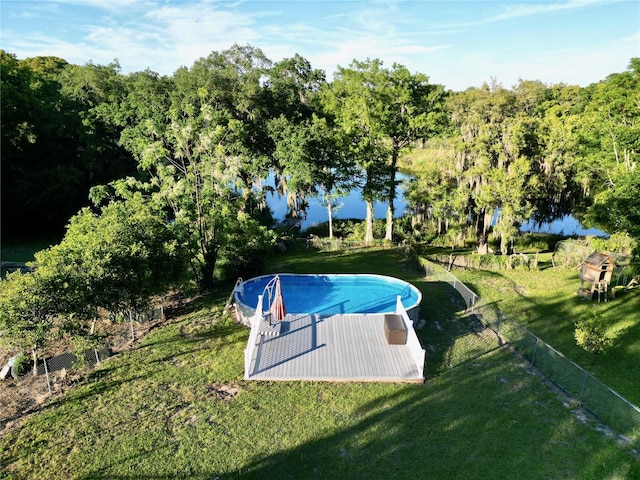 view of swimming pool featuring a yard and a water view