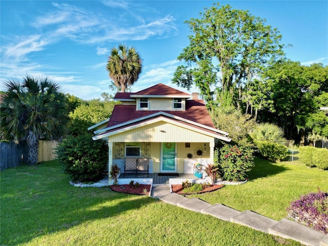 view of front of house with covered porch and a front lawn