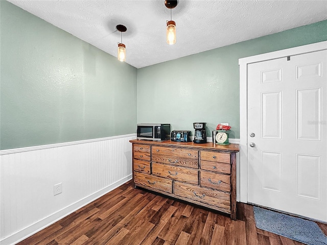 bedroom with a textured ceiling and dark hardwood / wood-style floors