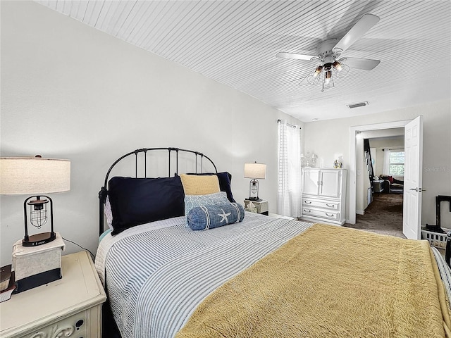 bedroom featuring multiple windows, ceiling fan, and carpet