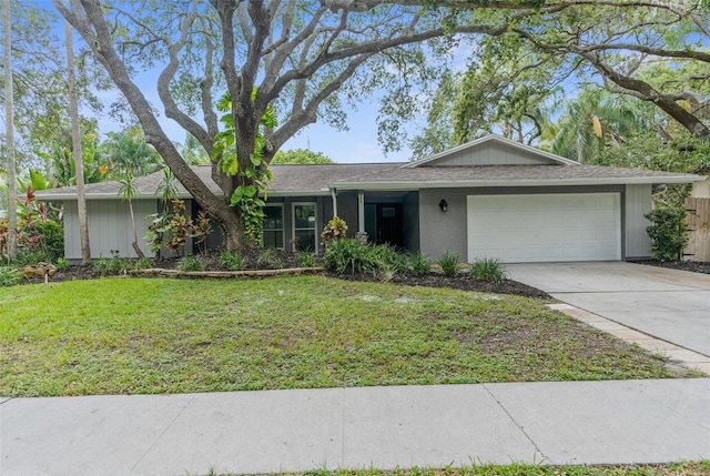 ranch-style house featuring a garage and a front lawn