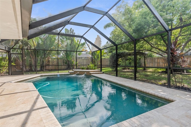 view of pool with pool water feature, glass enclosure, and a patio area