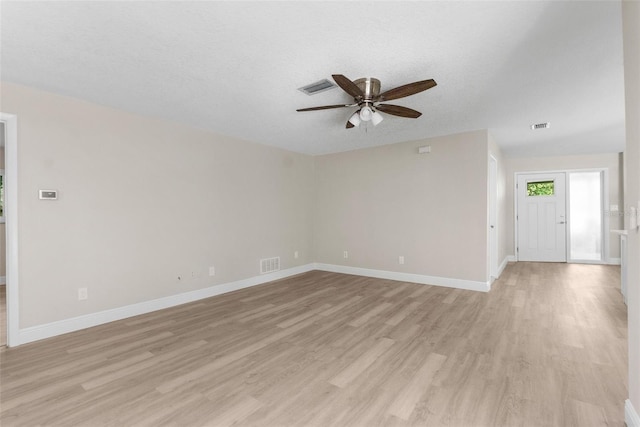 spare room featuring ceiling fan, a textured ceiling, and light wood-type flooring