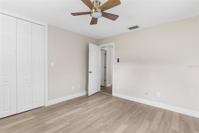 unfurnished bedroom featuring a closet, light hardwood / wood-style flooring, and ceiling fan