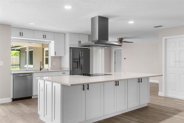 kitchen with ceiling fan, a large island, stainless steel appliances, island range hood, and white cabinets