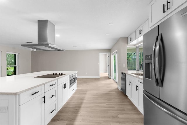 kitchen featuring ventilation hood, plenty of natural light, white cabinets, and appliances with stainless steel finishes