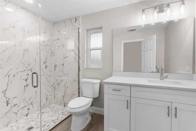 bathroom with vanity, wood-type flooring, a shower with shower door, and toilet