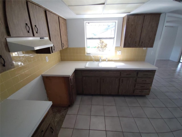 kitchen featuring light tile patterned flooring, sink, and decorative backsplash