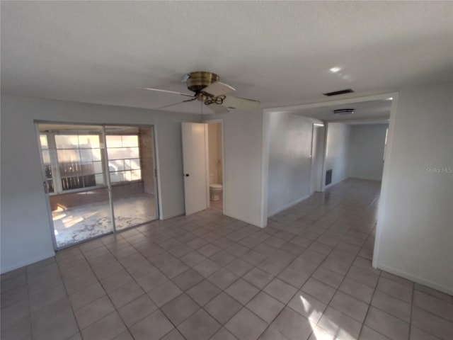 tiled empty room featuring ceiling fan