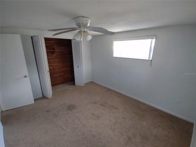 unfurnished bedroom with light carpet, a textured ceiling, ceiling fan, and a closet