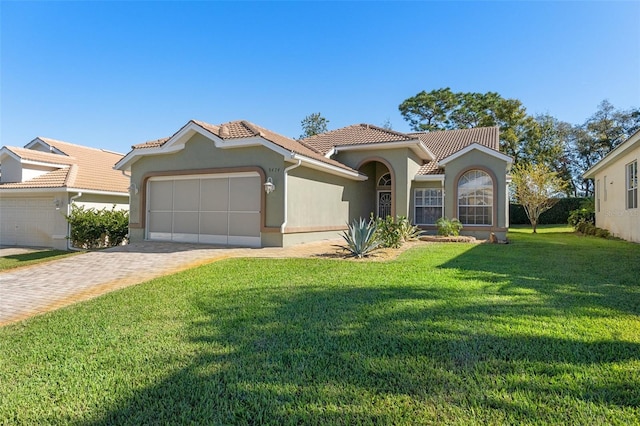 mediterranean / spanish home with a front yard and a garage