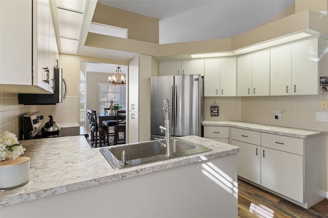 kitchen featuring electric stove, stainless steel fridge, a textured ceiling, dark hardwood / wood-style flooring, and white cabinetry