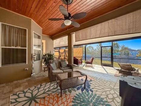 sunroom / solarium featuring ceiling fan and wood ceiling