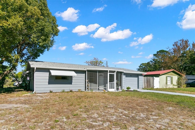 ranch-style house featuring a sunroom, a garage, and a front lawn