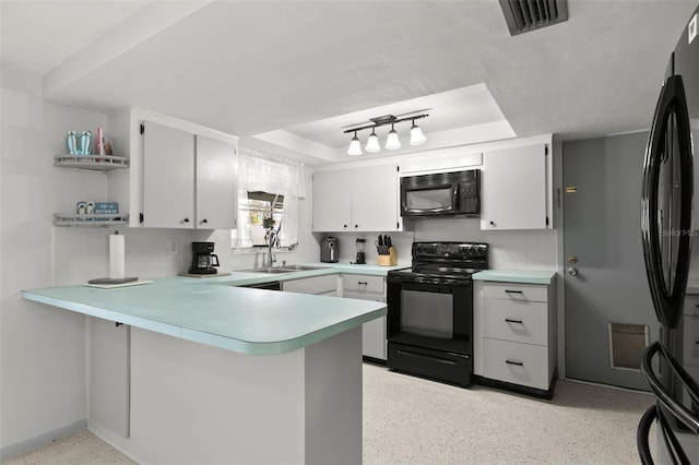 kitchen featuring backsplash, black appliances, sink, white cabinetry, and kitchen peninsula