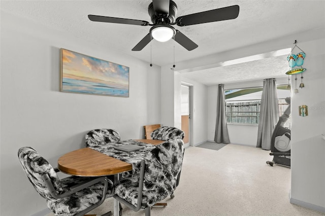 dining area with ceiling fan and a textured ceiling