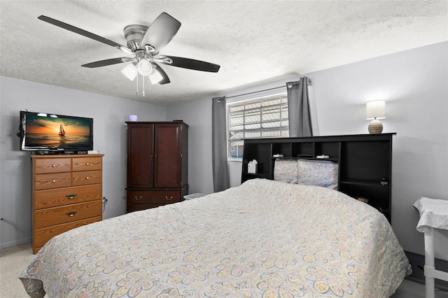 carpeted bedroom with ceiling fan and a textured ceiling