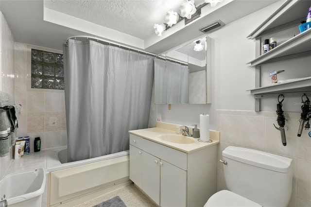 full bathroom with a textured ceiling, toilet, shower / bath combo with shower curtain, and tile walls