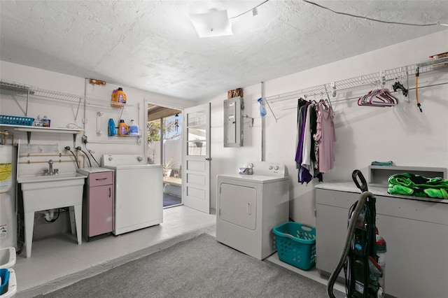 laundry area featuring a textured ceiling, electric panel, and separate washer and dryer