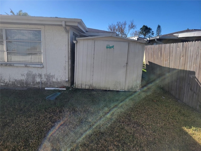 view of side of home featuring a yard and a storage shed