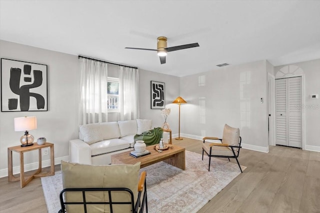 living room with light hardwood / wood-style flooring and ceiling fan