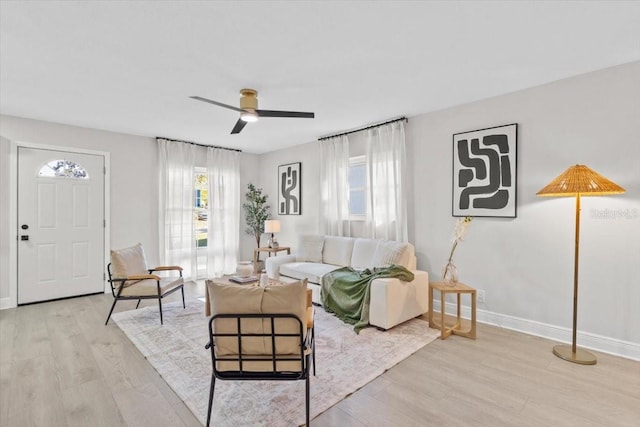 living room with ceiling fan and light hardwood / wood-style flooring