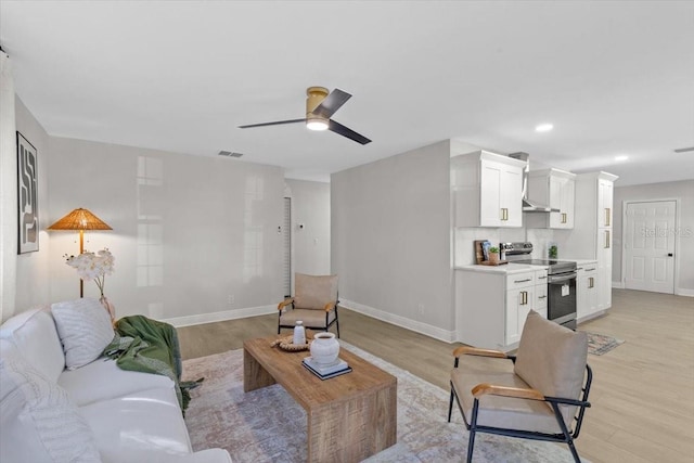 living room with light hardwood / wood-style floors and ceiling fan