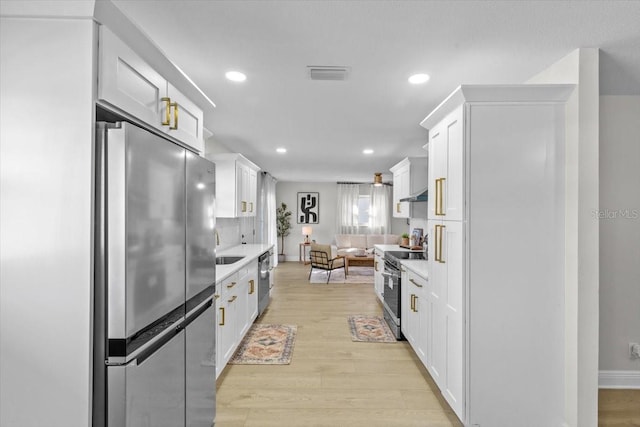 kitchen featuring white cabinetry, stainless steel appliances, and light hardwood / wood-style floors