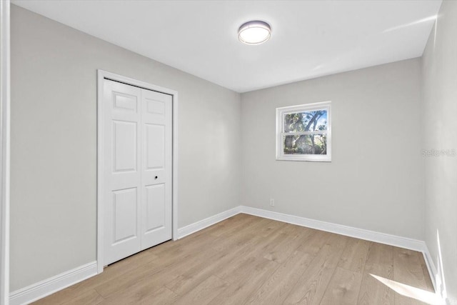 unfurnished bedroom featuring a closet and light hardwood / wood-style floors