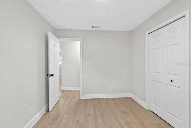 unfurnished bedroom featuring a closet and light wood-type flooring