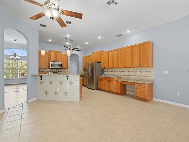 kitchen featuring a breakfast bar, decorative backsplash, light stone counters, kitchen peninsula, and stainless steel appliances